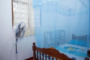 una camera con letto e ventilatore accanto a una finestra di Sagopearl Guest a Mirissa