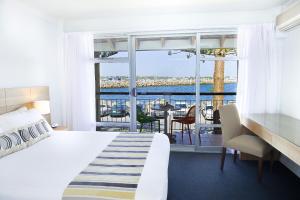 a hotel room with a bed and a view of the ocean at Be. Fremantle in Fremantle