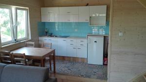 a kitchen with a table and a refrigerator at Domek nad morzem Mechowo in Mechowo