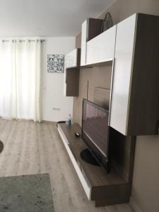 a living room with a flat screen tv in a cabinet at Apartamento Los Pinos in San Miguel de Salinas