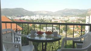 a table with a bowl of fruit on a balcony at Sweet guesthouse in Mostar