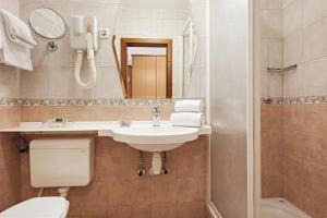 a bathroom with a sink and a toilet and a mirror at Hotel Termal - Terme 3000 - Sava Hotels & Resorts in Moravske Toplice