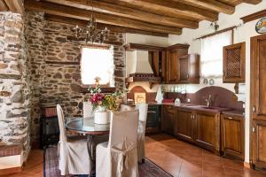 cocina con mesa y pared de piedra en Premium Stone House, en Vrasná