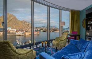 uma sala de estar com vista para a água e as montanhas em Thon Hotel Lofoten em Svolvær