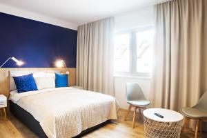 a bedroom with a bed with blue and white at Pokoje Deluxe Jarosławiec in Jarosławiec