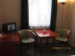 a room with a table and two chairs and a television at Neuenkirchener Hof in Neuenkirchen