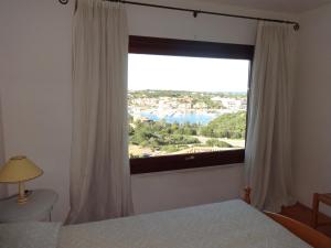 sypialnia z dużym oknem z widokiem w obiekcie Case Della Marina w mieście Porto Cervo