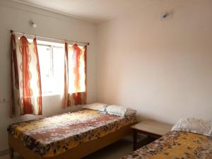um quarto com 2 camas e uma janela em Bodhgaya Guest House em Bodh Gaya