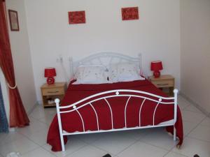 a bedroom with a red and white bed with two night stands at Chambres d'Hotes la Belle Taille in Lassay