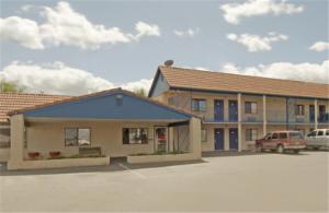 a building with a car parked in a parking lot at Travel Inn & Suite in Springerville