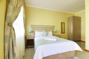 Un dormitorio con una cama grande y una ventana en Minilitha Lodge en Richards Bay