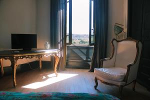 グリニャンにあるLa vie de chateauのデスク、椅子、窓が備わる客室です。