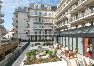 an apartment patio with a fountain in front of a building at Médicis Home Puteaux in Puteaux