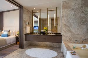 
a bathroom with a large mirror and a large tub at Studio City Hotel in Macau

