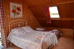 um pequeno quarto com uma cama e uma janela em Chambres d'hotes du creulet em Crouay