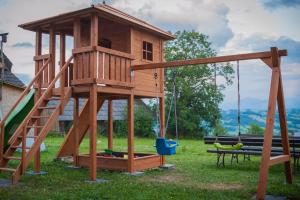 a wooden playground with a swing and a bench at U Repy in Bańska