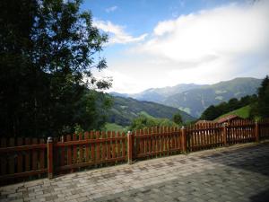 een houten hek met uitzicht op de bergen bij Ferienwohnung Roswitha in Zell am Ziller
