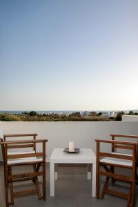 two chairs and a table with a candle on it at Amfitriti's Apartment in Naxos Chora