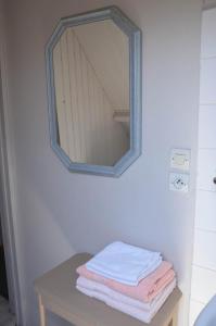 a mirror on a wall above a table with towels at Chambres d'hotes du creulet in Crouay