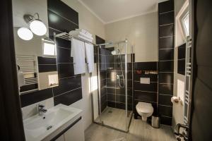 a bathroom with a toilet and a sink and a shower at Magnum Residence in Mamaia Nord +40 photos