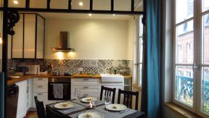 une cuisine avec une table avec des chaises et une salle à manger dans l'établissement Appartement Galerie, à Honfleur
