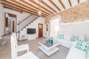 a living room with a white couch and a tv at Can Diana in Campanet