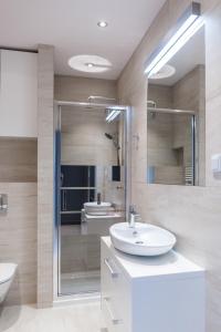 bagno con lavandino bianco e doccia di Dream&Travel Apartments a Cracovia