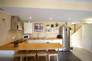 eine Küche mit einem Holztisch und einem Kühlschrank aus Edelstahl in der Unterkunft Livingtarifa Reserva de los Lances in Tarifa