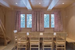 a dining room with a table and chairs and windows at Koča Predilnica Velika Planina in Kamniška Bistrica