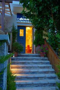 eine Treppe, die zu einem Restaurant mit blauer Tür führt in der Unterkunft Archipelagos Hotel in Fourni Ikaria