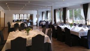 バート・ベリンゲンにあるGolfhotel Hebelhofの白いテーブルと黒い椅子が備わるレストラン