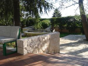 a park with a bench and a stone wall at Hotel Astoria in Alberobello