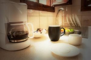 a kitchen counter with a coffee maker and cups on it at Thalassia Studios in Kalamitsa