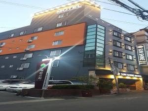 duży budynek z światłem ulicznym przed nim w obiekcie Sunshine Motel w Pusanie