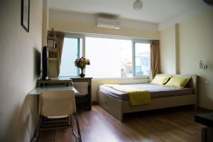 1 dormitorio con cama, escritorio y ventana en Lotus House en Hanói