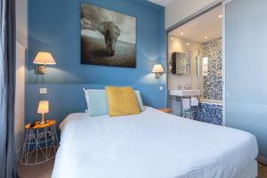 sypialnia z dużym białym łóżkiem i niebieskimi ścianami w obiekcie Florella Jean Jaures Apartment w Cannes