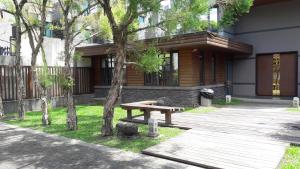 a wooden picnic table in front of a building at Sung-Ding Guesthouse in Ji'an