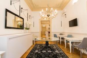 a dining room with a table and a chandelier at Residenza Degli Artisti in Trieste