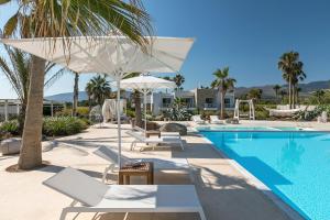 コス・タウンにあるWhite Pearls-Adults Only Luxury Suitesのスイミングプール(椅子、パラソル付)、