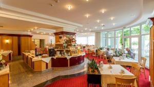 un restaurante con mesas y personas sentadas en mesas en Hotel Schneeberghof, en Puchberg am Schneeberg