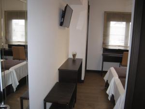 Habitación con 2 camas, mesa y espejo. en Suites Coruña en A Coruña