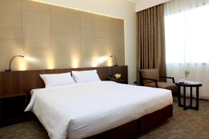 Louis Tavern Hotel في بانكوك: غرفة فندقية بسرير كبير وكرسي