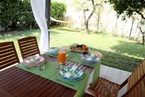 una mesa con platos de comida y un bol de fruta en SOHO Suite, en Fisciano