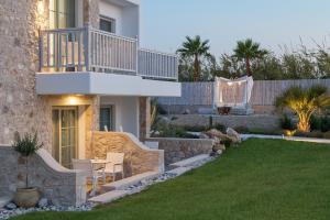 a backyard with a house and a lawn at White Pearls-Adults Only Luxury Suites in Kos Town