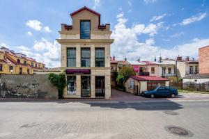 a building with a clock tower on top of a street at Apart Madryt in Tarnobrzeg