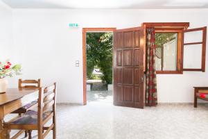 a dining room with a wooden door and a table at Saint Nicolas Bungalows in Arkasa