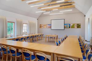 a conference room with tables and chairs and a whiteboard at Hotel Pavlov in Pavlov