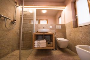 a bathroom with a sink and a toilet and a shower at Casa Al Rin in Valdidentro
