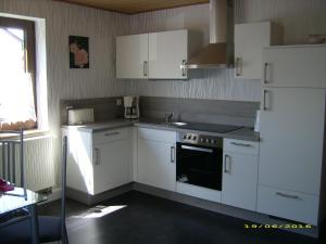 La cuisine est équipée de placards blancs et d'un four avec plaques de cuisson. dans l'établissement Ferienwohnung Meier Eveline, à Dollnstein