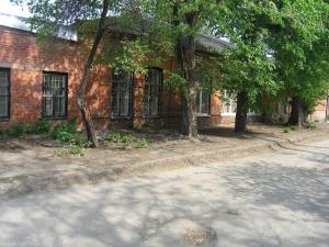 an old brick building with trees in front of it at Hostel Raiduzhny in Kharkiv